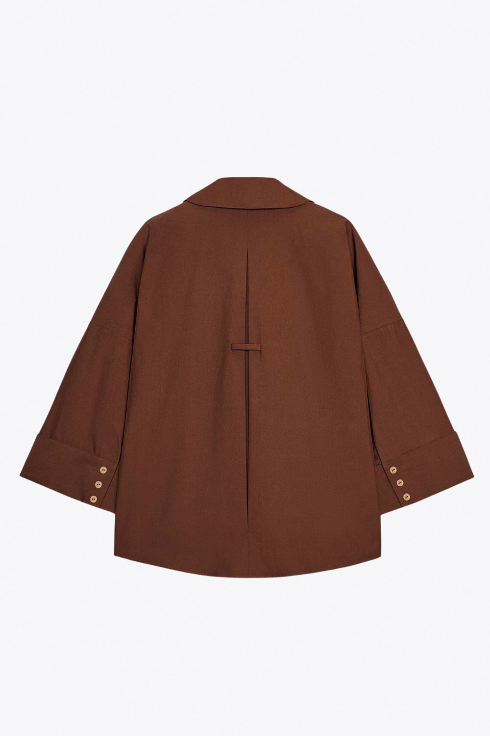 Camisa de fit oversized, manga 3/4 amplia con doblez en puños, cuello camisero, escote v, pinza de amplitud en espalda con trabilla decorativa y bajo curveado. Cierre frontal con hilera de botones en contraste.