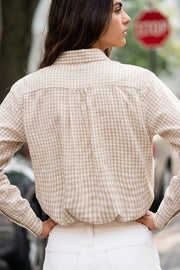 Camisa corta de estampado cuadros, cuello camisero, manga larga con puño abotonado, fit abullonado y bolsillo frontal. Cierre frontal con hilera de botones, pinza de amplitud en espalda y rib elástico en bajo.
