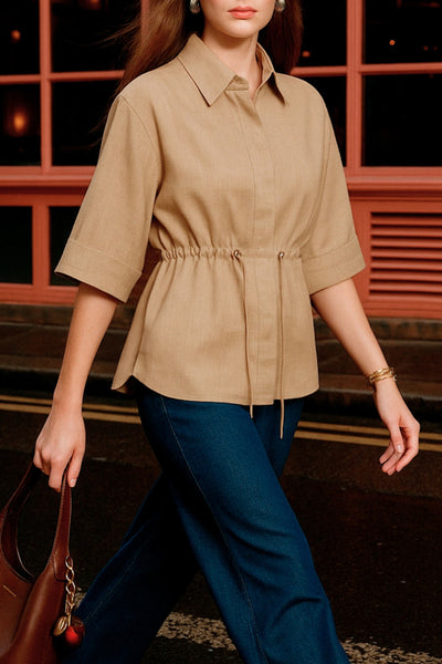 Camisa de fit oversized, manga 3/4 amplia con doblez en puños, cuello camisero y jareta ajustable en cintura. Cierre frontal con hilera oculta de botones.