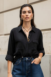 Camisa de fit oversized, manga larga amplia rolled up con trabillas y botón en contraste, cuello camisero y jareta ajustable en cintura. Cierre frontal con hilera oculta de botones.