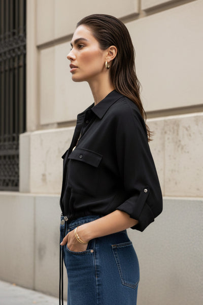 Camisa de fit oversized, manga larga amplia rolled up con trabillas y botón en contraste, cuello camisero y jareta ajustable en cintura. Cierre frontal con hilera oculta de botones.