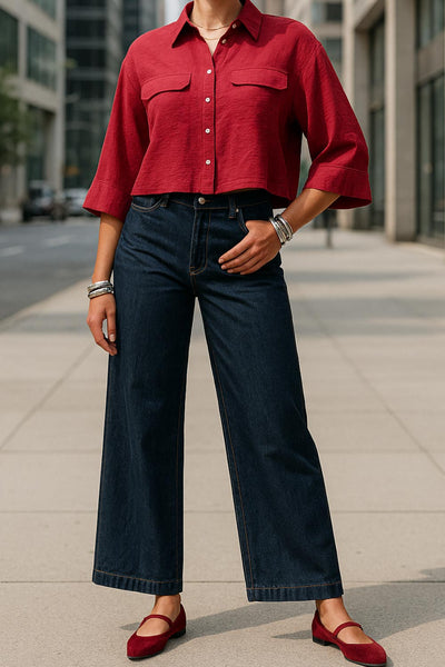 Camisa corta de fit oversized, manga 3/4 amplia con doblez en puños, cuello camisero, bolsillos frontales decorativos con cartera y pinza de amplitud en espalda. Cierre frontal con hilera de botones.