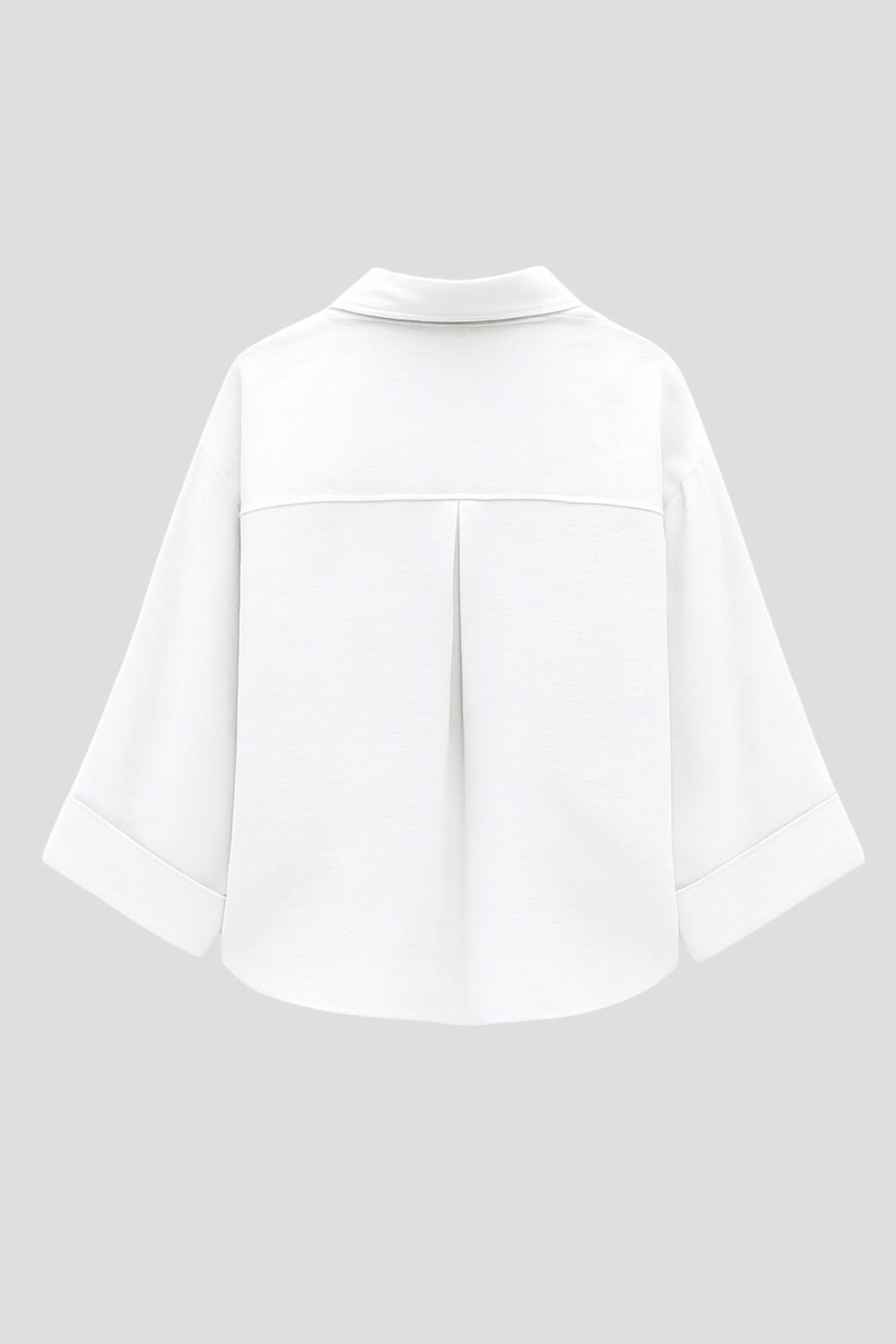 Camisa corta de fit oversized, manga 3/4 amplia con doblez en puños, cuello camisero, bolsillos frontales decorativos con cartera y pinza de amplitud en espalda. Cierre frontal con hilera de botones.