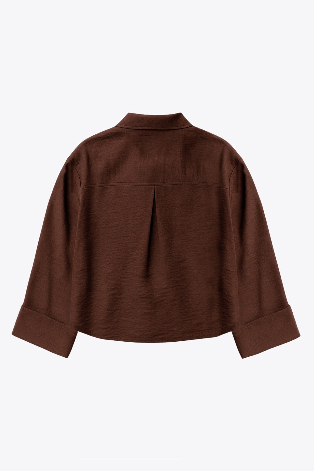 Camisa corta de fit oversized, manga 3/4 amplia con doblez en puños, cuello camisero, bolsillos frontales decorativos con cartera y pinza de amplitud en espalda. Cierre frontal con hilera de botones.