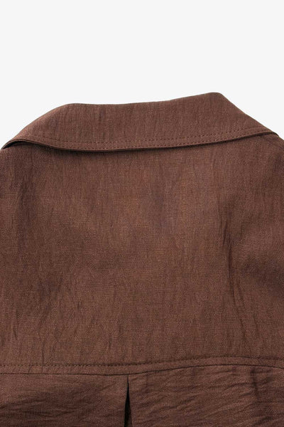 Camisa corta de fit oversized, manga 3/4 amplia con doblez en puños, cuello camisero, bolsillos frontales decorativos con cartera y pinza de amplitud en espalda. Cierre frontal con hilera de botones.