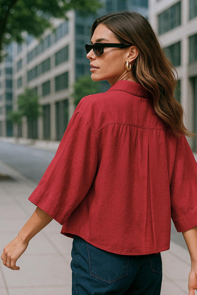 Camisa corta de fit oversized, manga 3/4 amplia con doblez en puños, cuello camisero, bolsillos frontales decorativos con cartera y pinza de amplitud en espalda. Cierre frontal con hilera de botones.