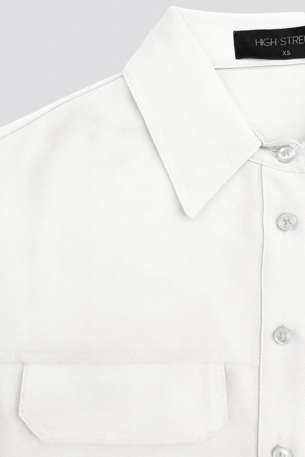 Camisa corta de fit oversized, manga 3/4 amplia con doblez en puños, cuello camisero, bolsillos frontales decorativos con cartera y pinza de amplitud en espalda. Cierre frontal con hilera de botones.