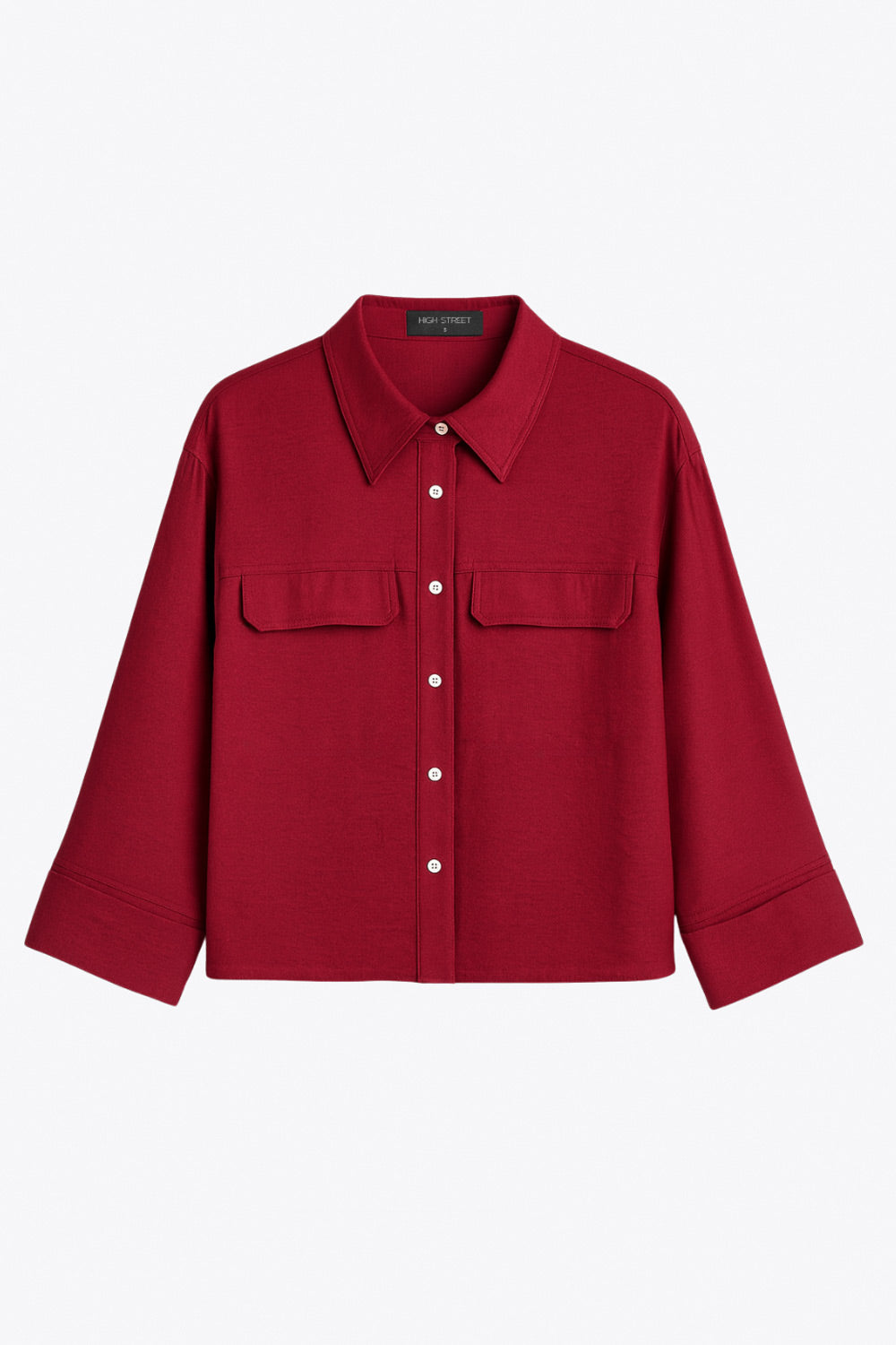 Camisa corta de fit oversized, manga 3/4 amplia con doblez en puños, cuello camisero, bolsillos frontales decorativos con cartera y pinza de amplitud en espalda. Cierre frontal con hilera de botones.