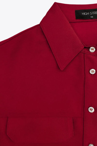 Camisa corta de fit oversized, manga 3/4 amplia con doblez en puños, cuello camisero, bolsillos frontales decorativos con cartera y pinza de amplitud en espalda. Cierre frontal con hilera de botones.