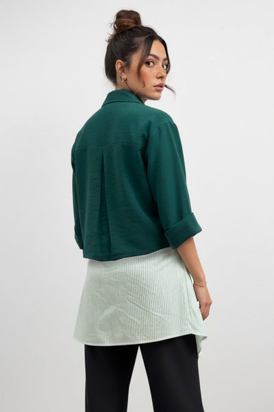 Camisa corta de estilo utilitario. Corte recto, silueta amplia y largo crop. Frente con cuello camisero clásico, tapeta de botones y dos bolsillos con tapa en el pecho. Espalda con canesú y tablón central invertido.