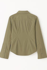 Camisa de fit ajustado, cuello camisero, manga larga amplia con botones, pinzas, bajo curveado y cierre frontal con hilera de botones.