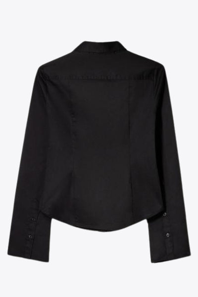 Camisa de fit ajustado, cuello camisero, manga larga amplia con botones, pinzas, bajo curveado y cierre frontal con hilera de botones.