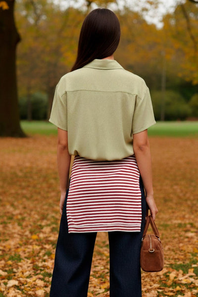 Camisa corta de lino, fit recto, manga corta, cuello camisero, bolsillo frontal de parche, bajo curveado con aberturas laterales y cierre frontal con hilera de botones.