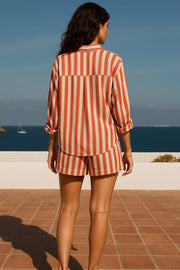 Camisa corta de estampado rayas, fit oversized, manga larga rolled up con trabilla ajustable, cuello camisero, detalle de bajo curveado y pinza de amplitud en espalda. Cierre frontal con cruce de botones.