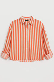 Camisa corta de estampado rayas, fit oversized, manga larga rolled up con trabilla ajustable, cuello camisero, detalle de bajo curveado y pinza de amplitud en espalda. Cierre frontal con cruce de botones.