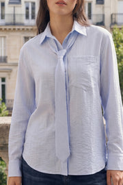 Camisa de fit oversized, estampado rayas, cuello camisero, manga larga con puño abotonado, pinza de amplitud en espalda, bolsillo frontal, bajo curveado y cierre frontal con hilera de botones. Detalle de corbata del mismo tejido.