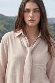 Camisa de fit oversized, estampado rayas, cuello camisero, manga larga con puño abotonado, pinza de amplitud en espalda, bolsillo frontal, bajo curveado y cierre frontal con hilera de botones. Detalle de corbata del mismo tejido.