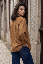 Camisa de pana, fit oversized, cuello camisero, manga larga con puño abotonado y bajo curveado. Cierre frontal con hilera de botones en contraste.