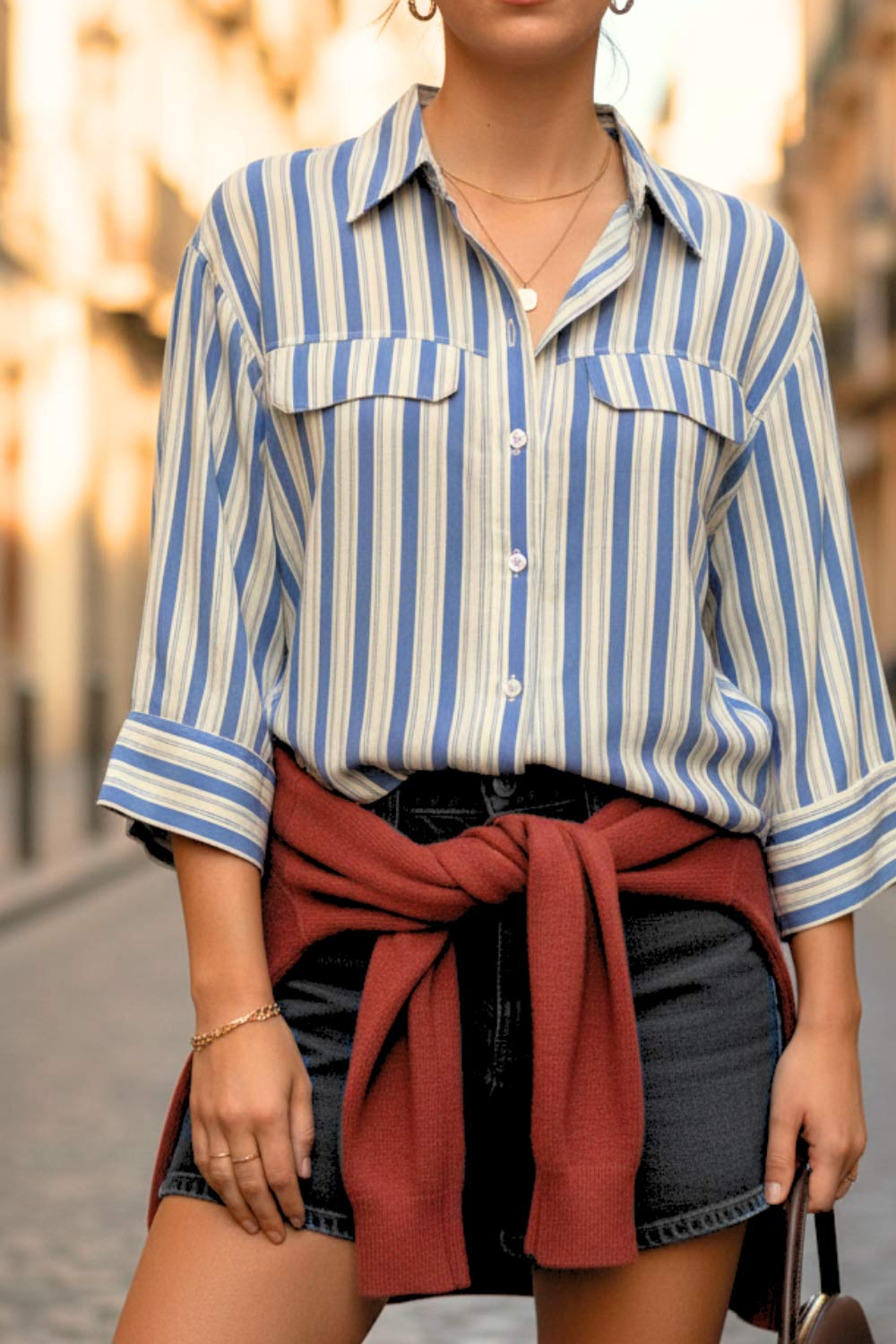 Camisa corta de estampado rayas, fit oversized, manga 3/4 amplia con doblez en puños, cuello camisero, bolsillos frontales decorativos con cartera y pinza de amplitud en espalda. Cierre frontal con hilera de botones.