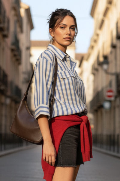 Camisa corta de estampado rayas, fit oversized, manga 3/4 amplia con doblez en puños, cuello camisero, bolsillos frontales decorativos con cartera y pinza de amplitud en espalda. Cierre frontal con hilera de botones.