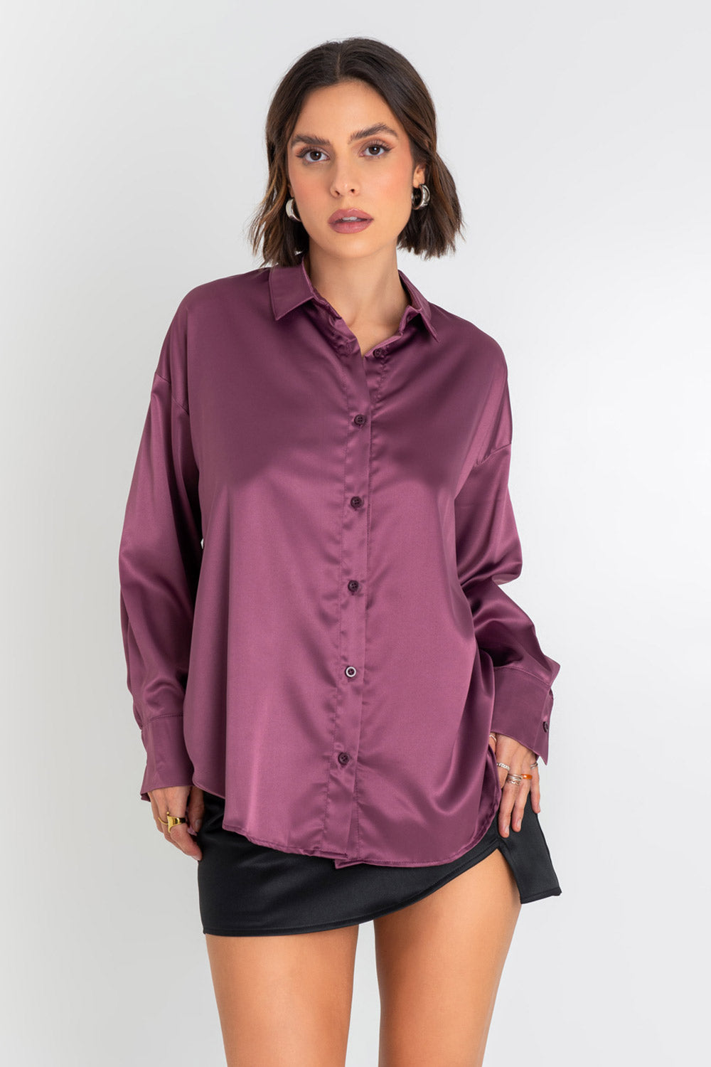 Camisa satinada de fit oversized, manga larga con puño abotonado, cuello camisero, bajo curveado, pinza de amplitud en espalda y cierre frontal con hilera de botones.