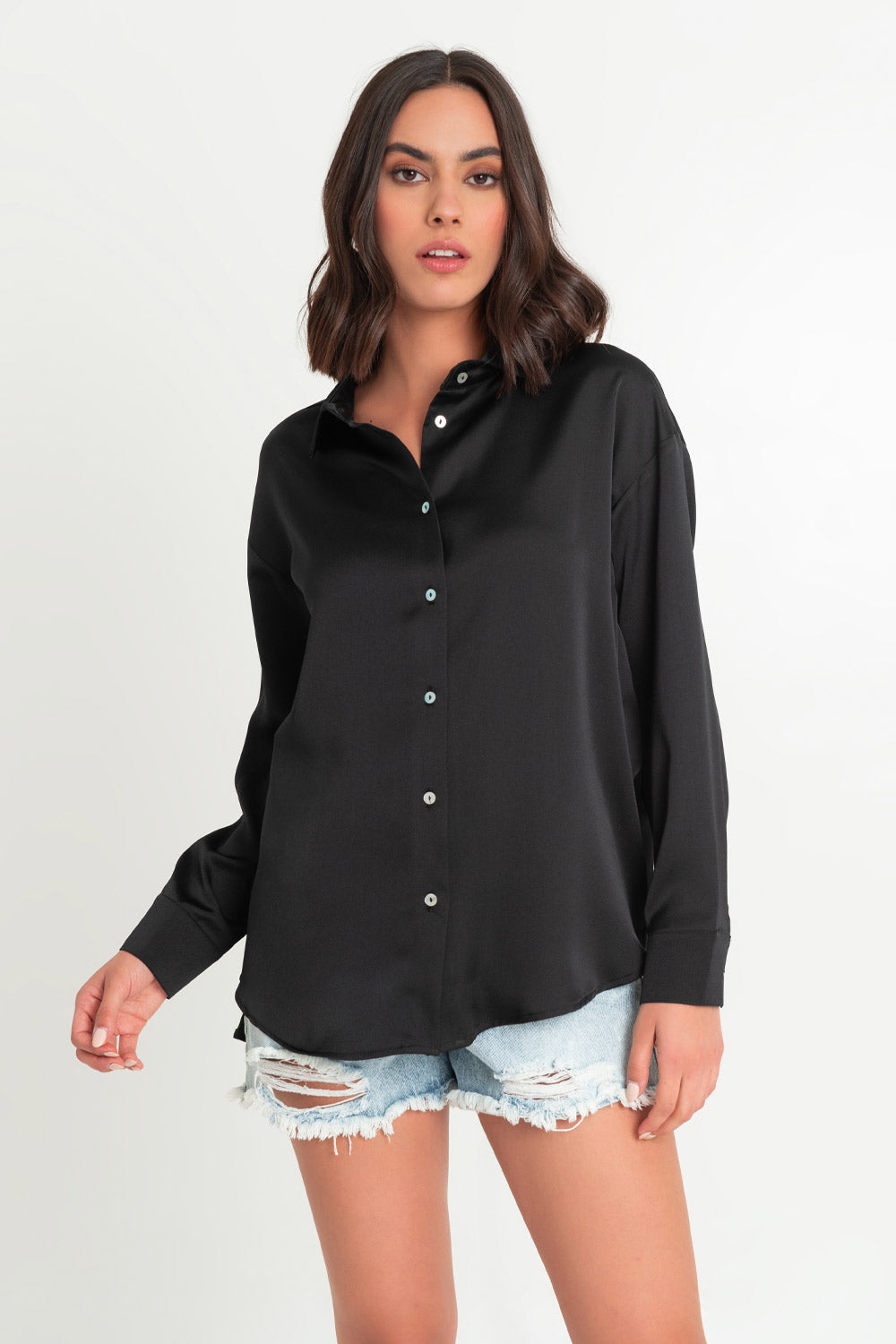 Camisa satinada de fit ligeramente oversized, manga larga con puño abotonado, cuello camisero, bajo curvado y cierre frontal con hilera de botones.