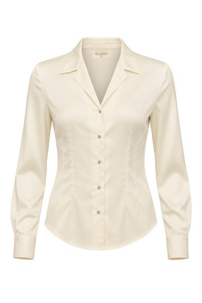Camisa satinada de fit ajustado, cuello camisero con solapa y cuello en v, manga larga con puño abotonado, bajo curveado, pinzas frontales y posteriores. Cierre frontal con hilera de botones en contraste.