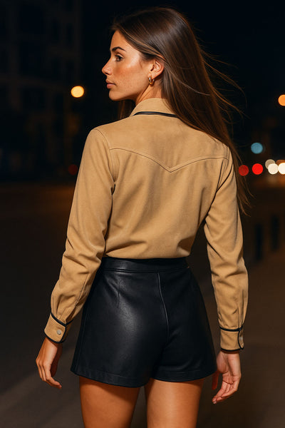 Camisa de gamuza, manga larga con puño abotonado, cuello camisero, bolsillos delanteros con cartera y botón en contraste, bajo curveado, corte decorativo en espalda y cierre frontal con hilera de botones en contraste. Detalle de bordes en contraste.