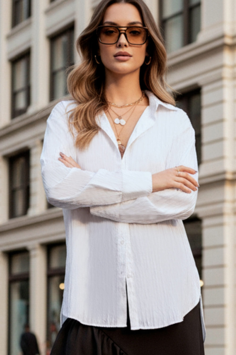 Camisa oversized de fit recto, manga larga con puño abotonado, cuello camisero, bajo curveado y cierre frontal con hilera de botones. Detalle de textura en tejido.