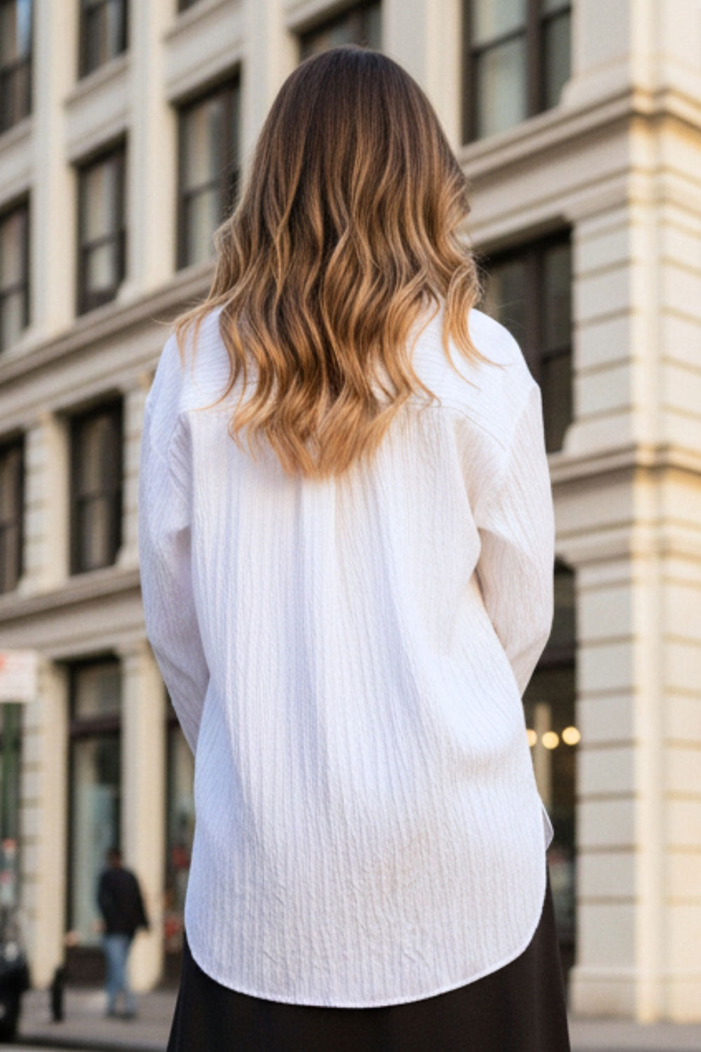 Camisa oversized de fit recto, manga larga con puño abotonado, cuello camisero, bajo curveado y cierre frontal con hilera de botones. Detalle de textura en tejido.