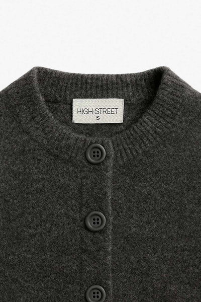 Cardigan de punto, fit recto, manga larga con rib de contraste en puños y cuello redondo. Cierre frontal con hilera de botones.