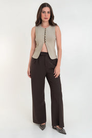 Chaleco de fit ajustado, cuello redondo, cierre frontal con hilera de botones en contraste, con abertura frontal en bajo y detalle de lazado ajustable en espalda.