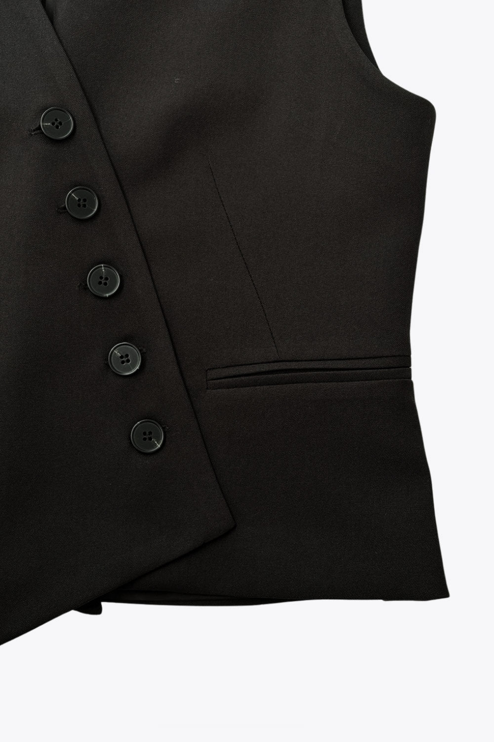 Chaleco asimétrico de fit recto, escote v, vivos decorativos delanteros y cierre frontal con hilera de botones en diagonal. Detalle de bajo asimétrico.