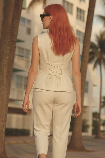 Chaleco ajustado de cuello redondo, pinzas frontales, fit recto, cierre frontal con hilera de botones en contraste, abertura frontal en bajo y lazado ajustable posterior.