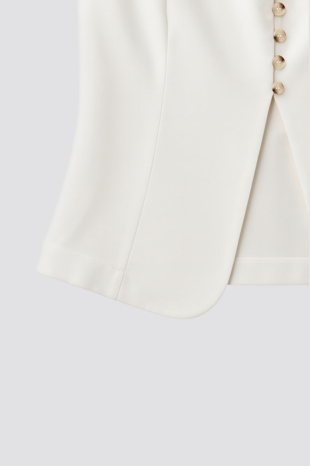 Chaleco ajustado de cuello redondo, pinzas frontales, fit recto, cierre frontal con hilera de botones en contraste, abertura frontal en bajo y lazado ajustable posterior.