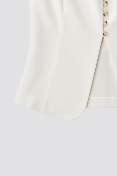 Chaleco ajustado de cuello redondo, pinzas frontales, fit recto, cierre frontal con hilera de botones en contraste, abertura frontal en bajo y lazado ajustable posterior.