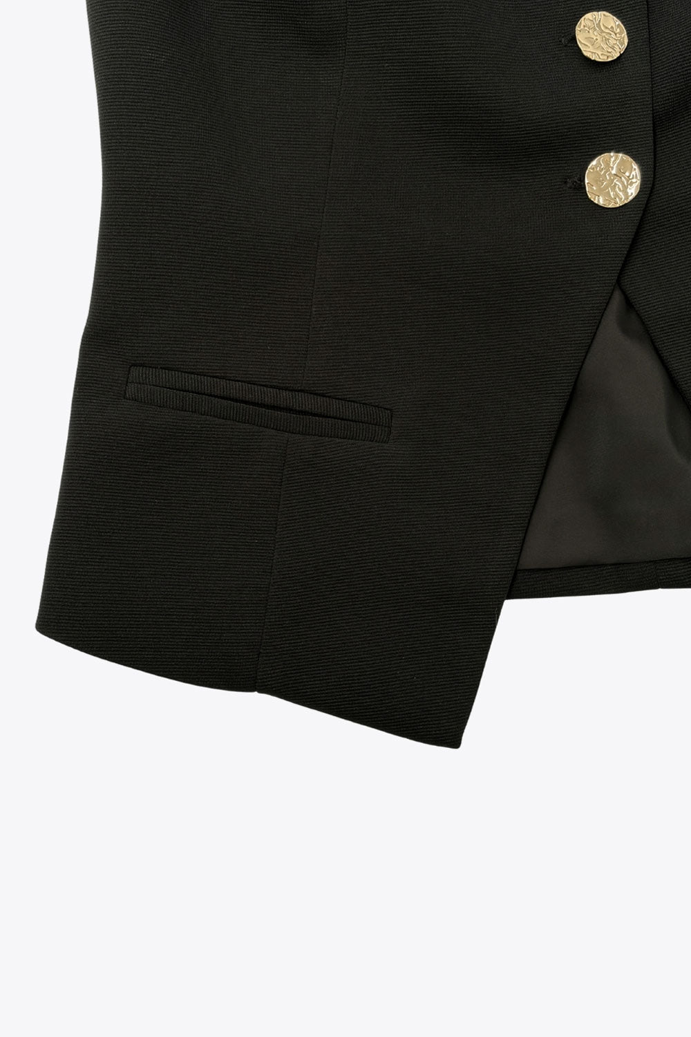 Chaleco corto de fit ajustado, cuello redondo, pinzas frontales, vivos decorativos y abertura frontal en bajo. Cierre frontal con hilera de botones en contraste.