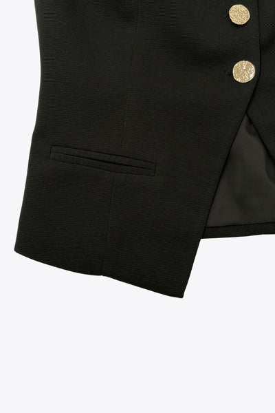 Chaleco corto de fit ajustado, cuello redondo, pinzas frontales, vivos decorativos y abertura frontal en bajo. Cierre frontal con hilera de botones en contraste.