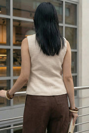 Chaleco de bouclé, fit ajustado, cuello redondo, vivos decorativos, pinzas frontales, cierre frontal con hilera de botones en contraste y abertura frontal v en bajo.