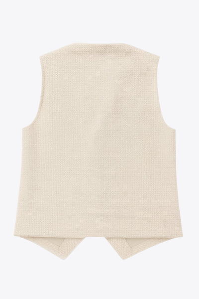 Chaleco de bouclé, fit recto, escote v, cierre con hilera de botones en contraste y abertura frontal v en bajo.