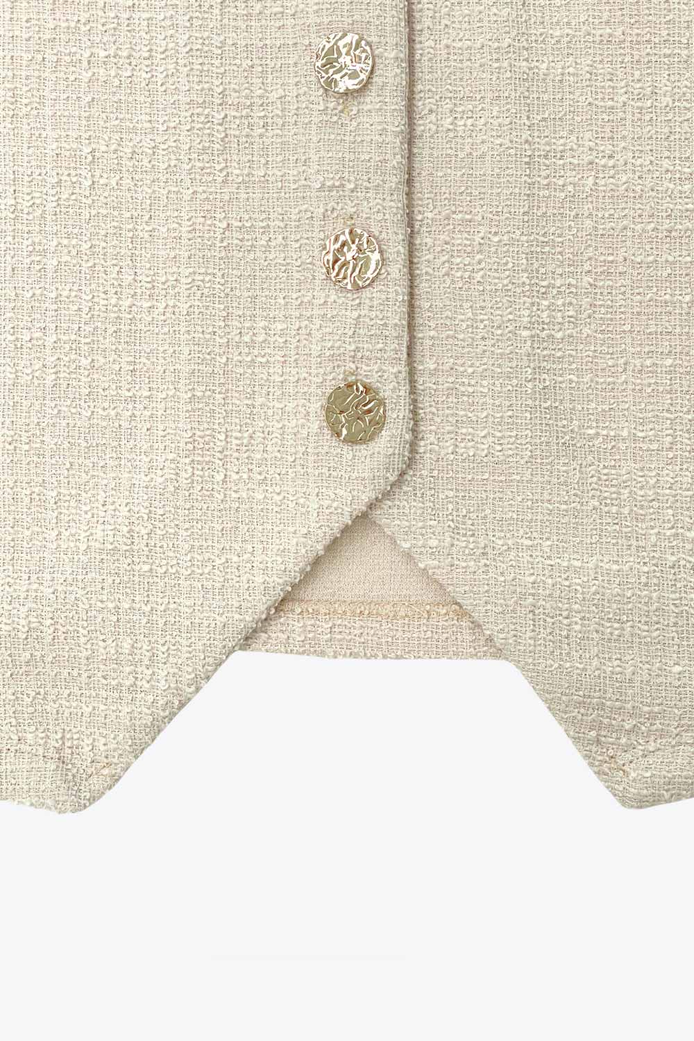 Chaleco de bouclé, fit recto, escote v, cierre con hilera de botones en contraste y abertura frontal v en bajo.