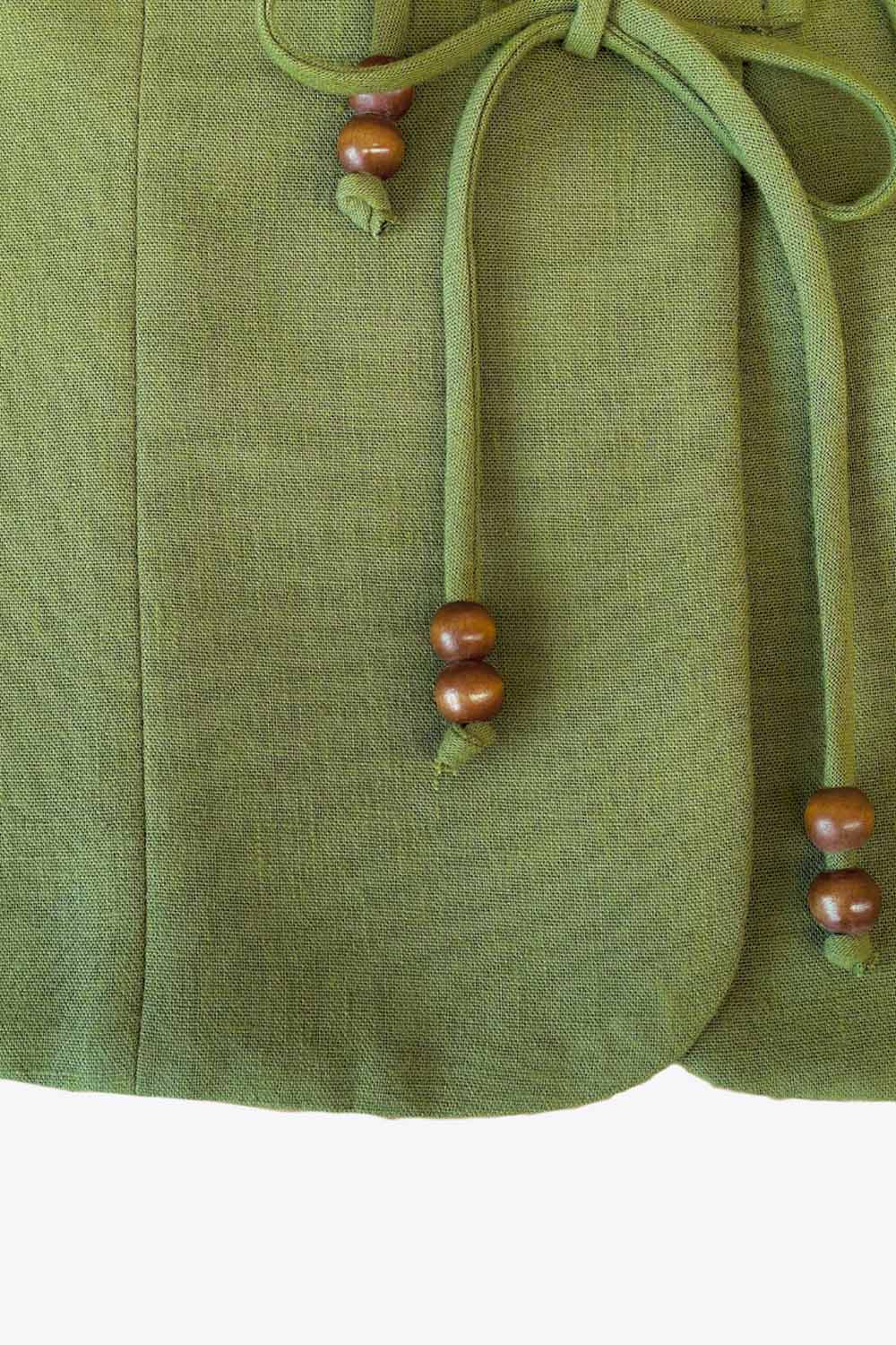 Blusa sin mangas, de fit recto, pinzas frontales, escote v redondeado y cierre frontal de lazos amarrables con detalle en contraste.