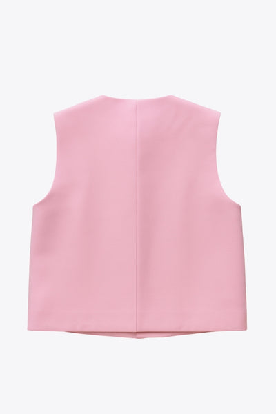 Chaleco corto de fit recto, cuello redondo, pinzas frontales, bolsillos delanteros de parche y cierre frontal con hilera de botones en contraste.