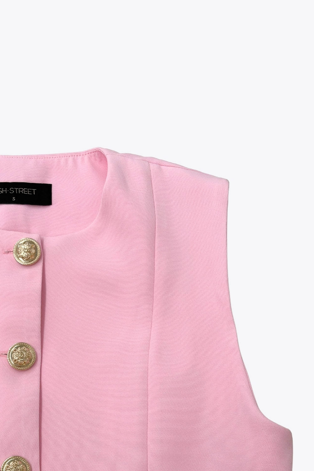 Chaleco corto de fit recto, cuello redondo, pinzas frontales, bolsillos delanteros de parche y cierre frontal con hilera de botones en contraste.