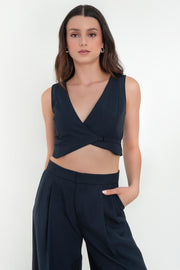 Chaleco corto, escote v cruzado, fit ajustado, bajo v curveado frontal y cierre con trabilla lateral ajustable.