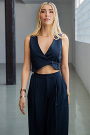 Chaleco corto, escote v cruzado, fit ajustado, bajo v curveado frontal y cierre con trabilla lateral ajustable.