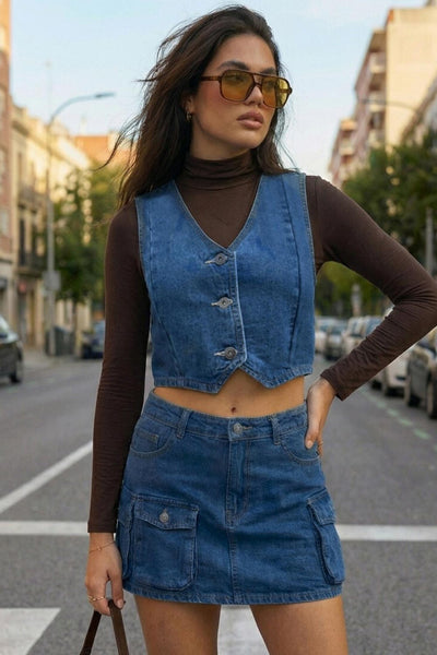 Chaleco corto de denim, escote v, pinzas con costuras frontales y cierre frontal con hilera de botones.