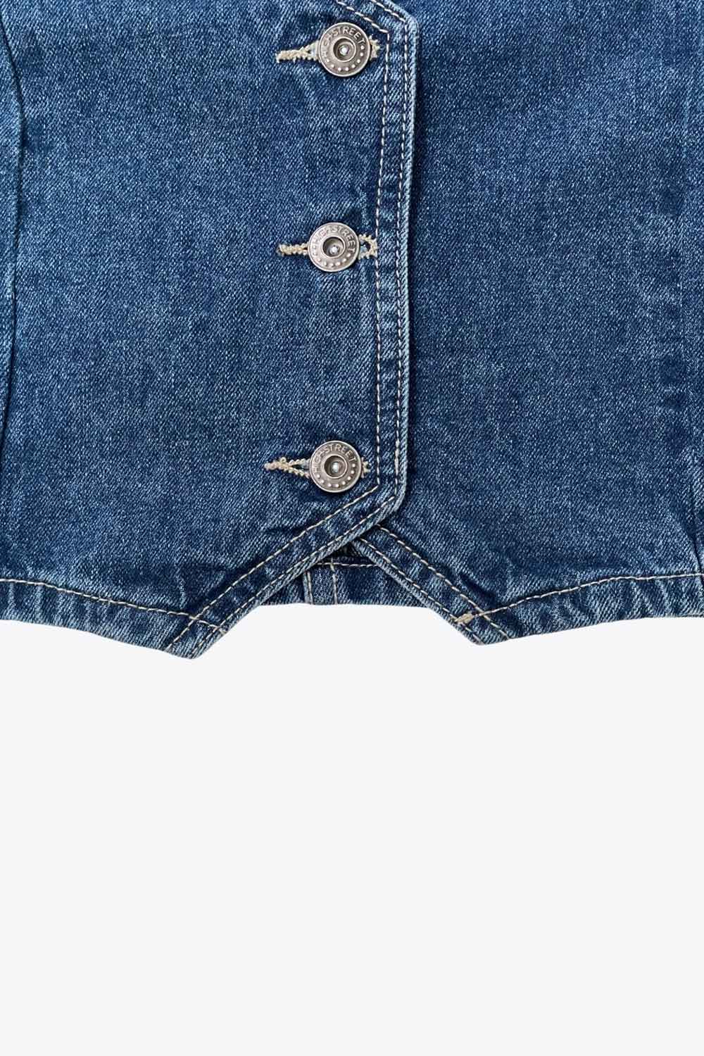 Chaleco corto de denim, escote v, pinzas con costuras frontales y cierre frontal con hilera de botones.