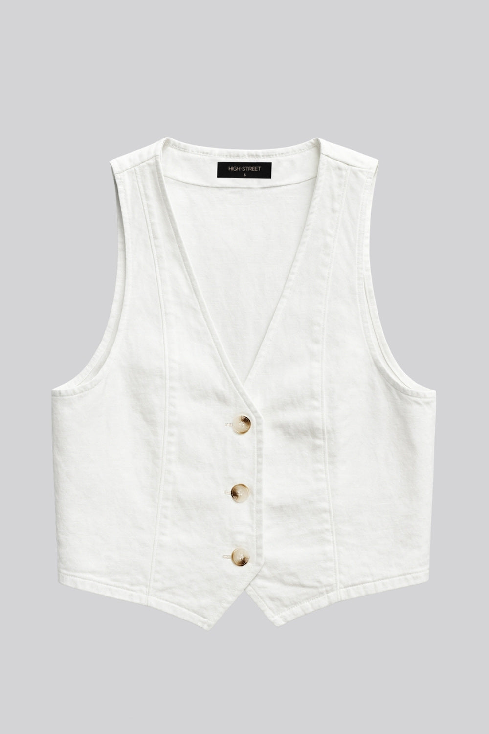 Chaleco corto de denim, fit ajustado, costuras frontales, escote v u y bajo v frontal. Cierre frontal con hilera de botones en contraste.