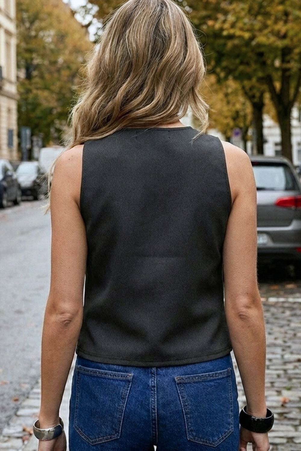 Chaleco corto de fit recto, cuello redondo y cierre frontal con hilera de botones en contraste. Detalle de abertura frontal en bajo.